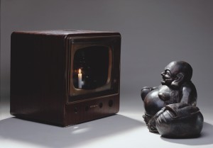 Нам Джун Пайк: Улыбающийся Будда (Buddha Looking at Old Candle TV), 1992 Металлический монитор, бронза, свеча (Будда: 40 x 60 x 30 см; Монитор: 55 x 55 x 48 см). © Nam June Paik Estate